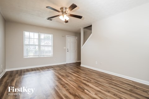 A room with wooden floors and a ceiling fan.