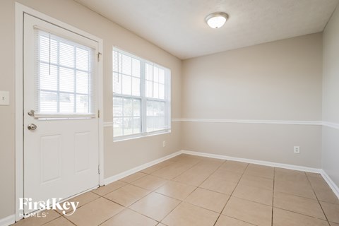 A room with a white door and a window with blinds.