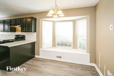 A kitchen with black cabinets and a white island.