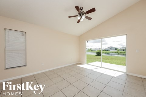 a living room with a large window and a ceiling fan