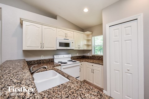 the kitchen is updated with granite counter tops and white appliances