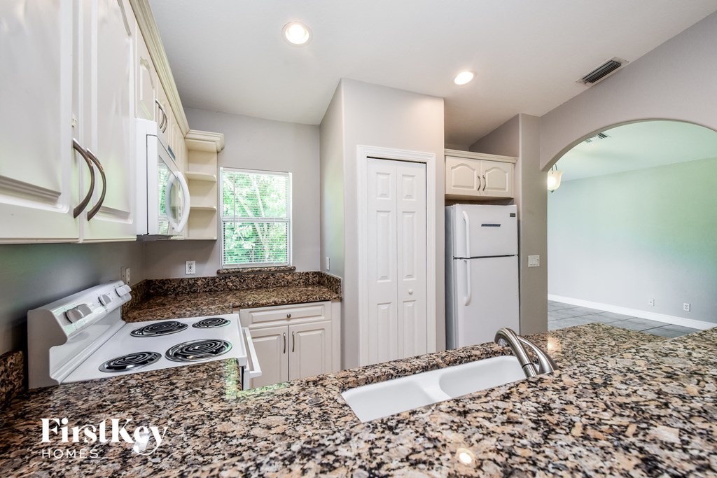 a kitchen with granite counter tops and white appliances