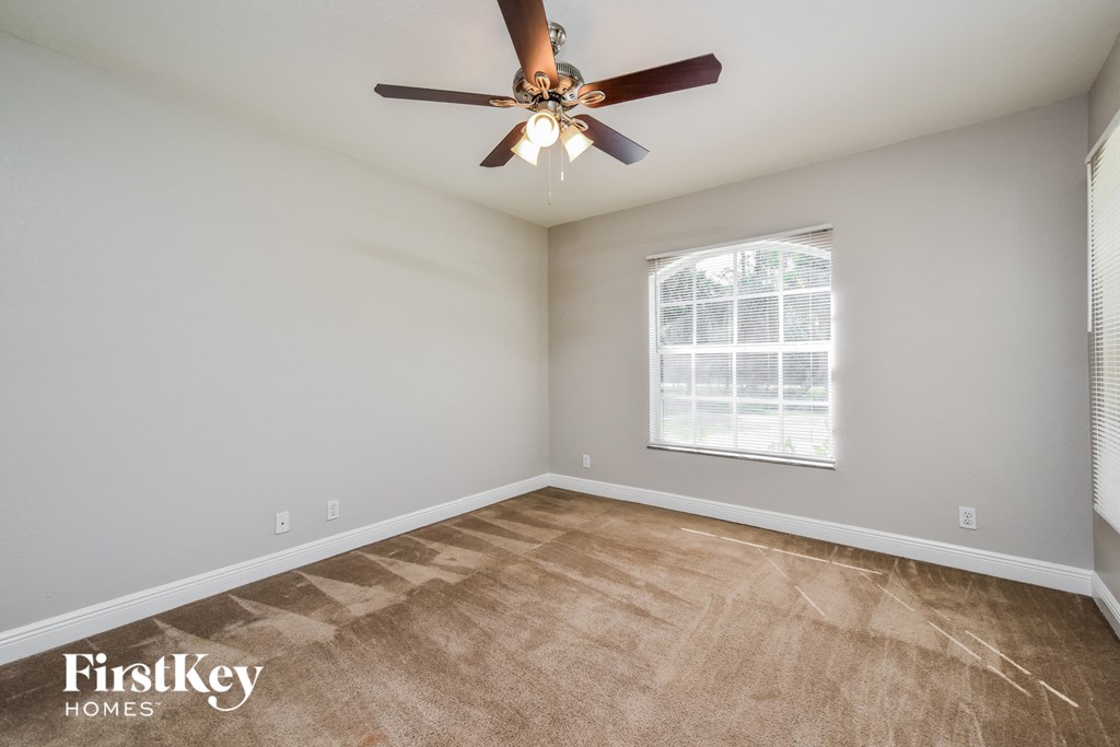 a bedroom with a ceiling fan and a window