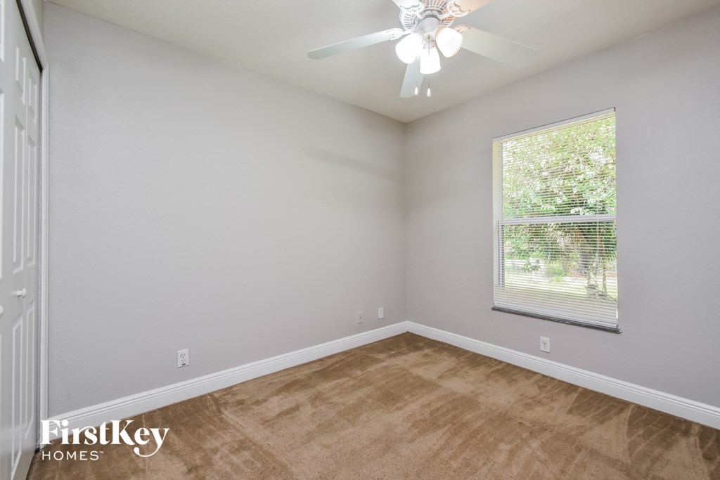 a bedroom with a ceiling fan and a window