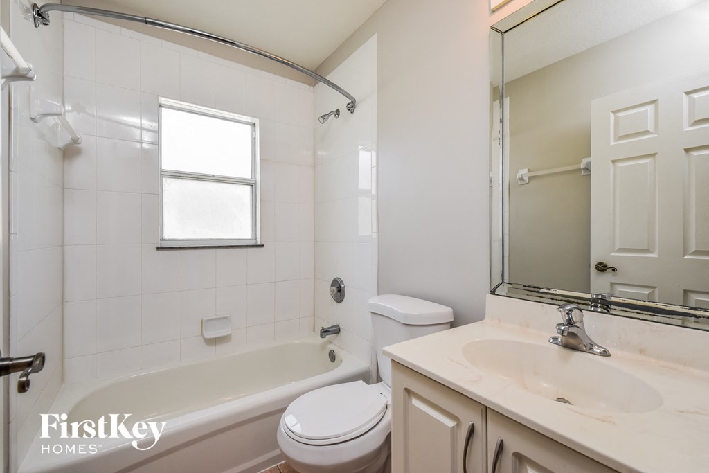 a white bathroom with a tub and a sink and a toilet