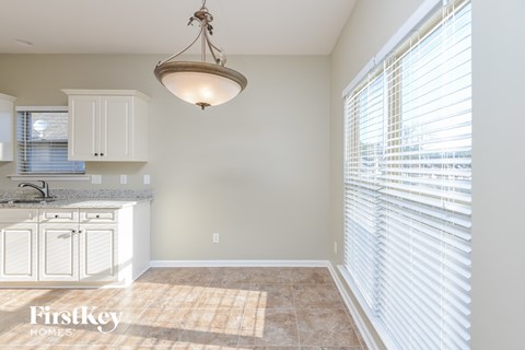 a kitchen with white cabinets and a sink and a large window