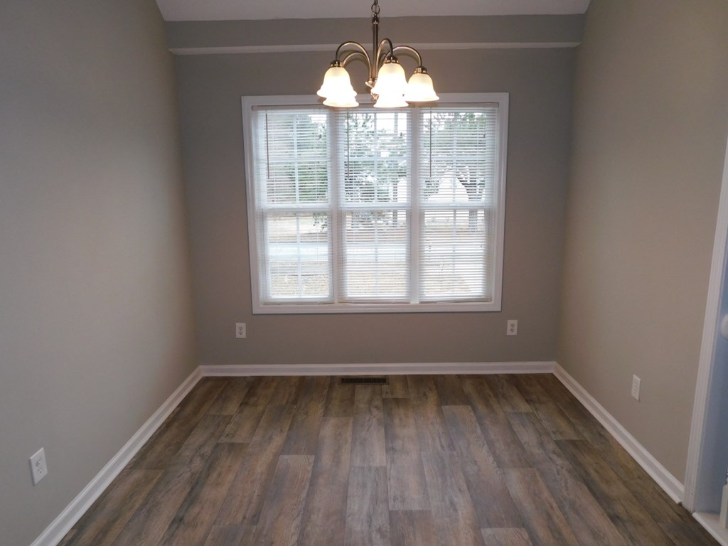 an empty living room with a window and wood floors