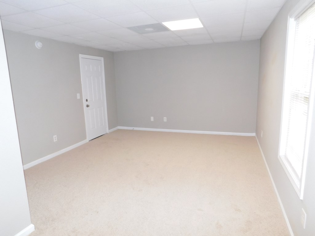 an empty room with a white carpet and a door