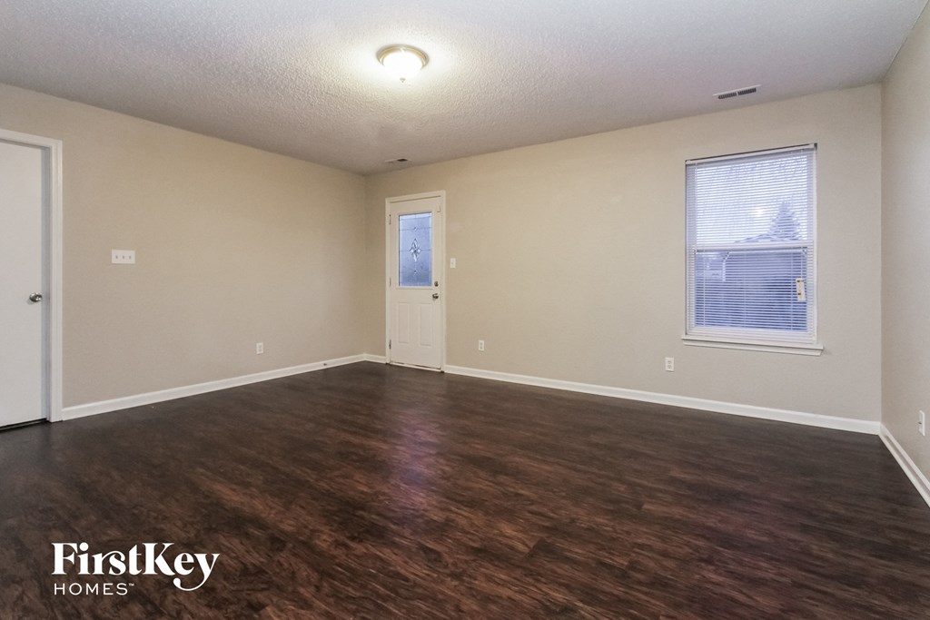 the living room of an empty house with wood flooring