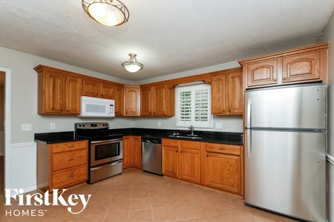 A kitchen with wooden cabinets and a stainless steel refrigerator.