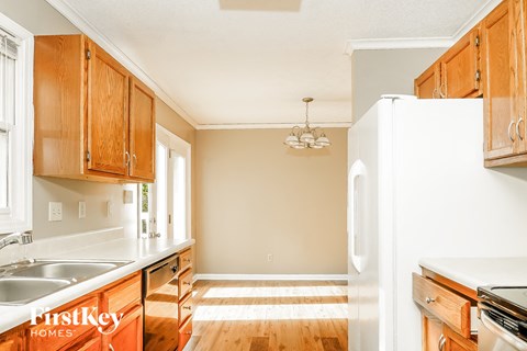 A kitchen with wooden cabinets and a white refrigerator.