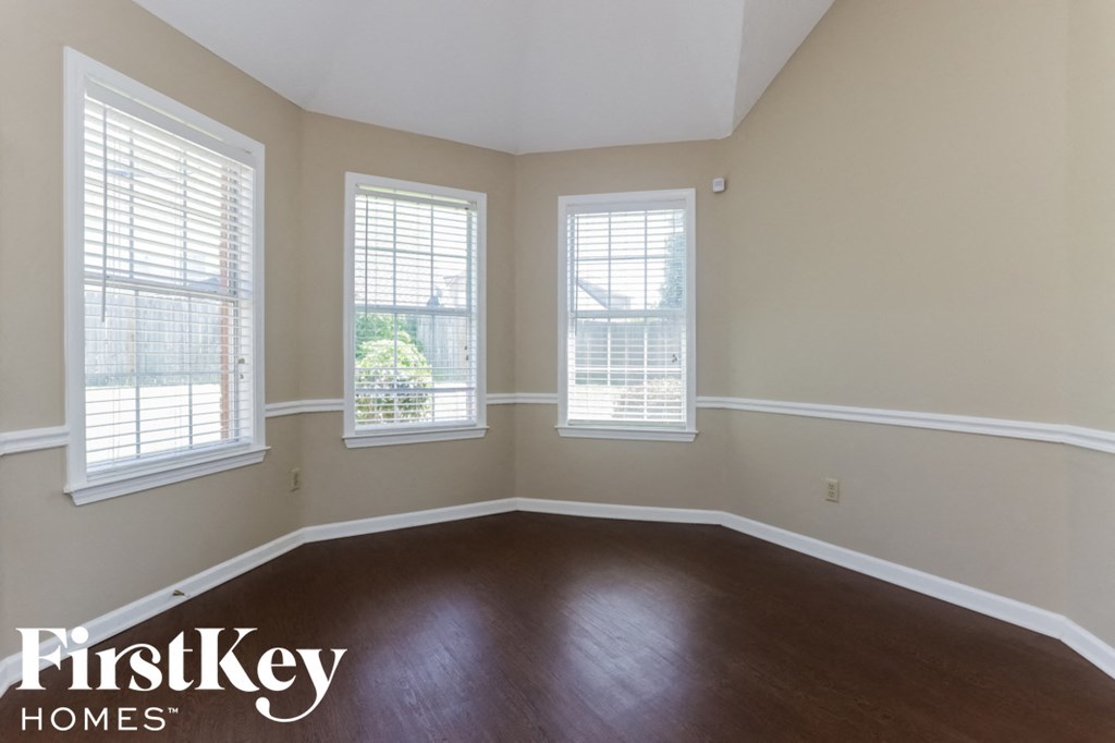 A room with wooden floors and two windows.