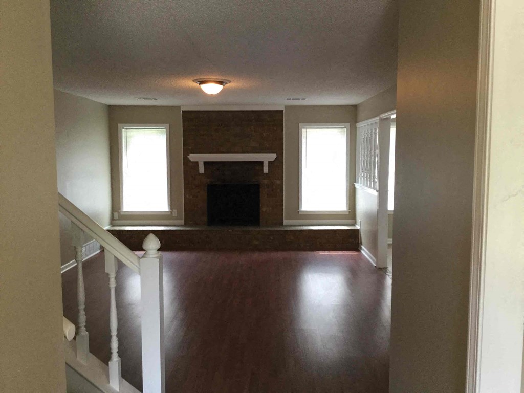 A room with a fireplace and a staircase.