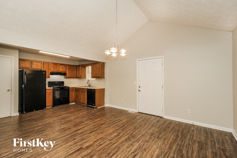 a kitchen and living room with wood flooring and black appliances