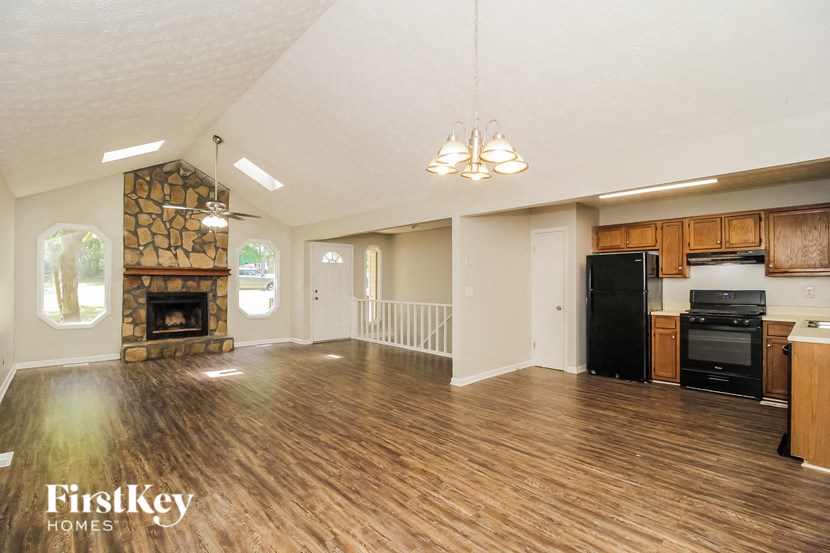 a kitchen and living room with a fireplace and wooden floors