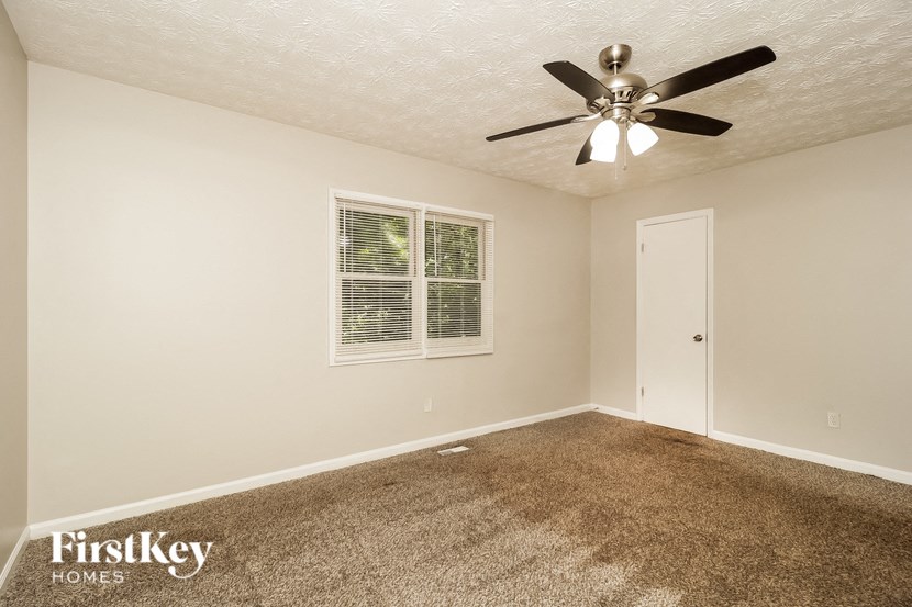 a bedroom with carpet and a ceiling fan