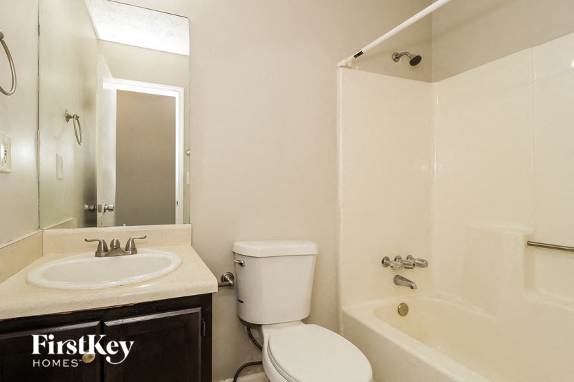 a bathroom with a toilet sink and tub and a mirror