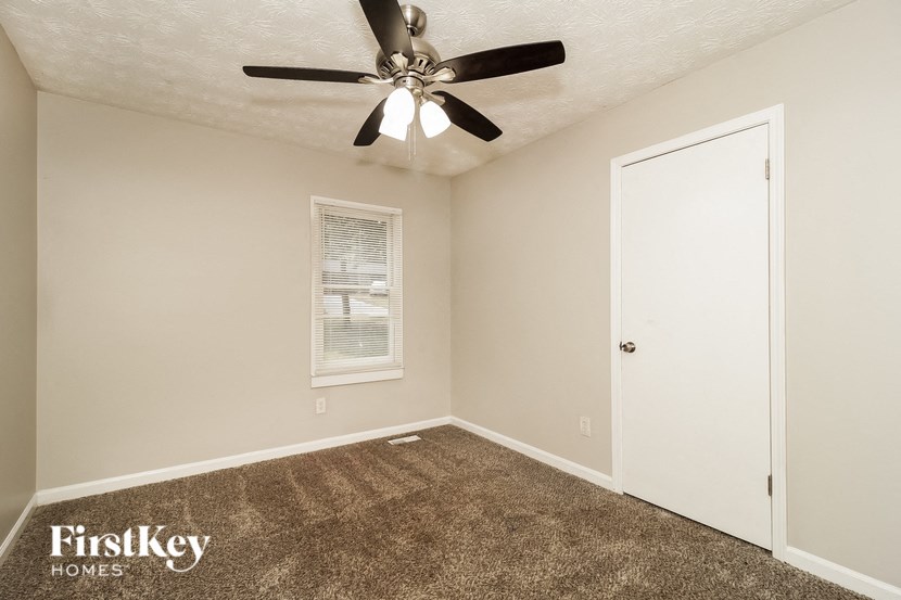 a bedroom with carpet and a ceiling fan