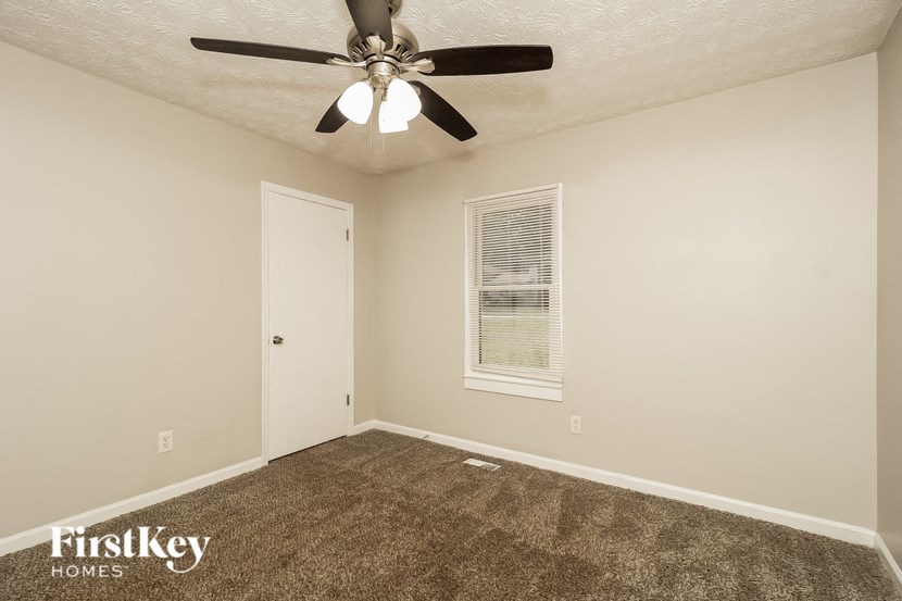 the living room of a home with a ceiling fan and carpet