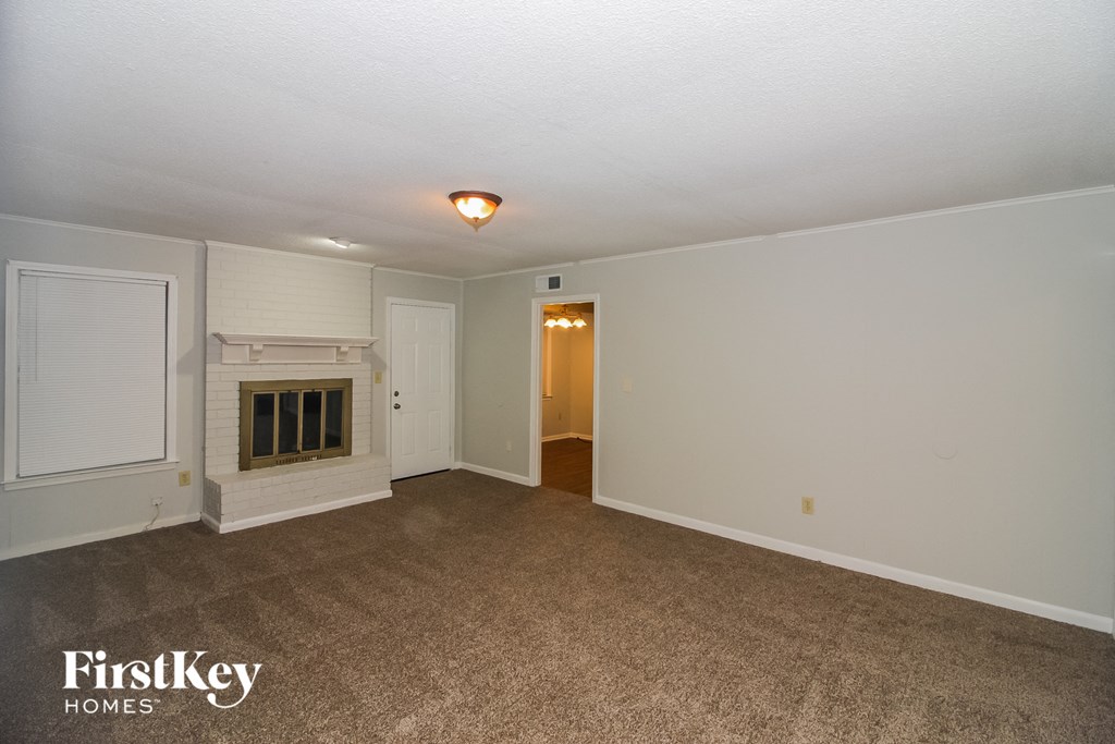 the living room of an empty house with a fireplace