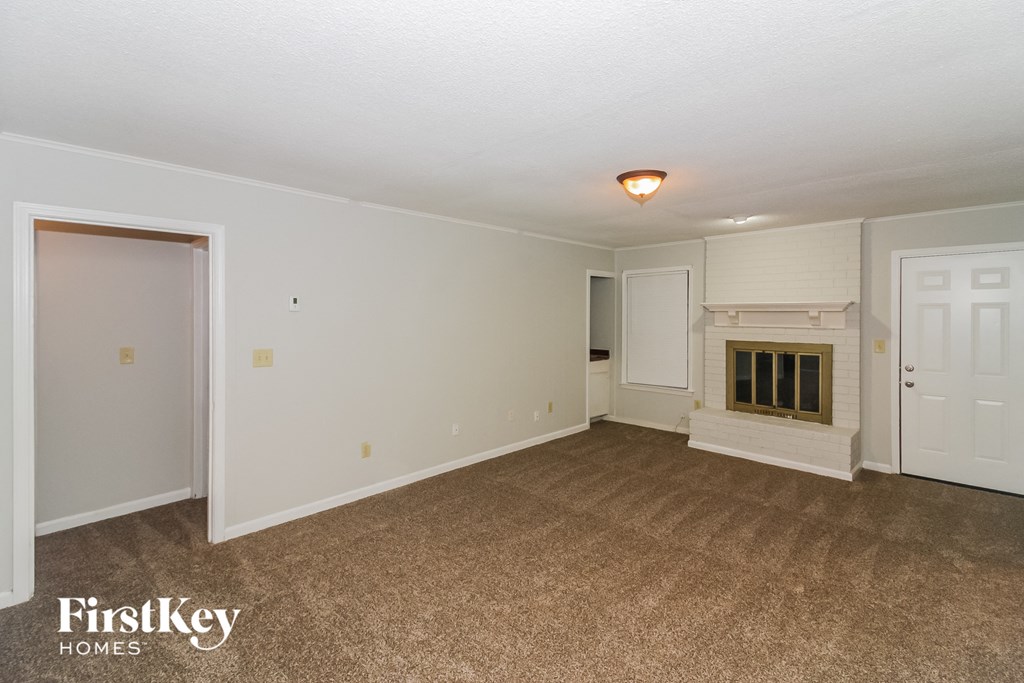 the living room of an empty house with a fireplace