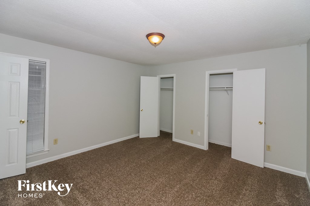 a bedroom with a carpeted floor and two closets