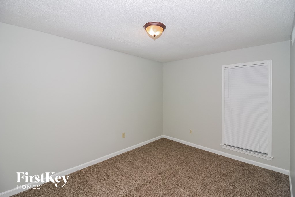 a bedroom with a carpeted floor and a large window