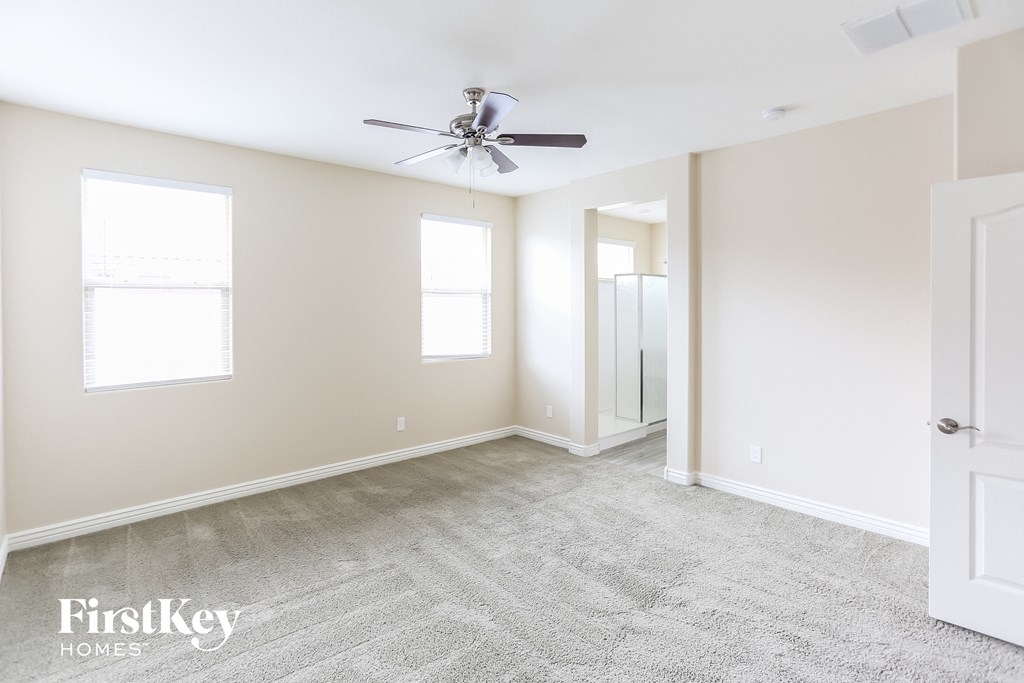 a empty bedroom with a ceiling fan and a closet