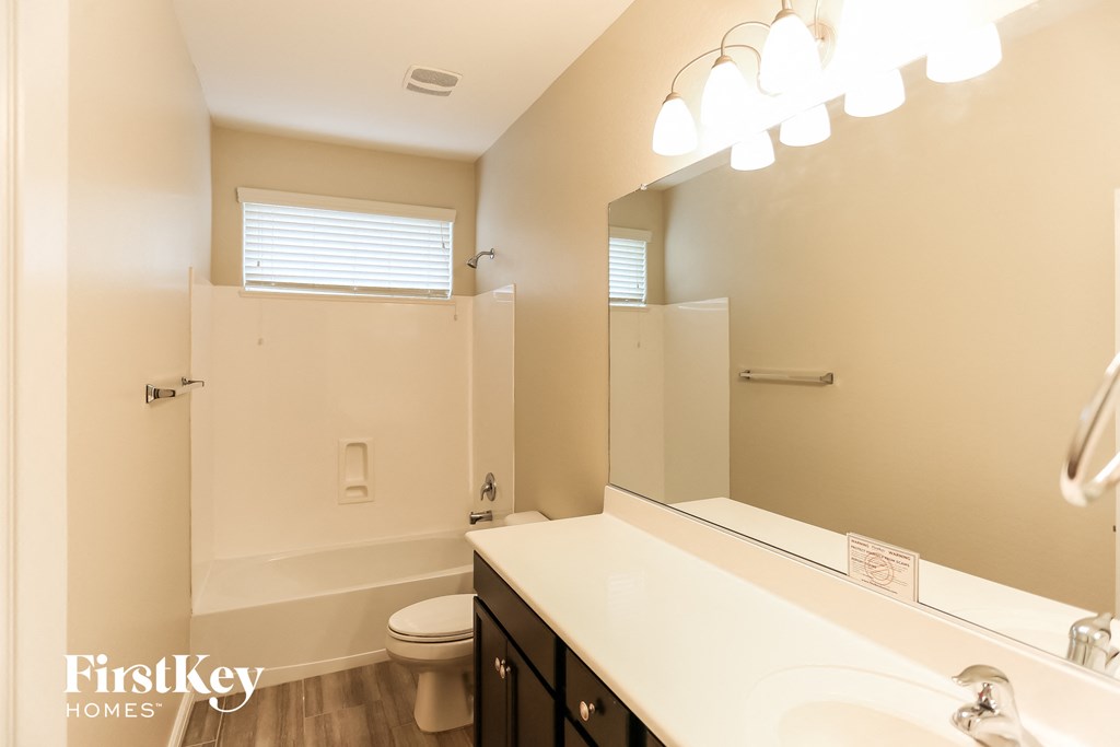 a bathroom with a toilet and a sink and a mirror