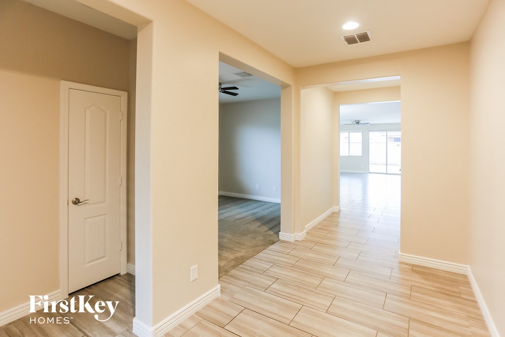 a hallway with a white door and a hard wood floor