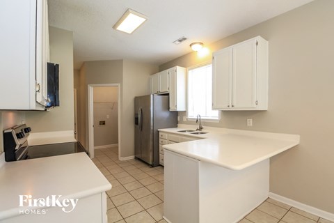 A kitchen with white cabinets and a white counter top.