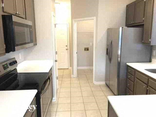 A kitchen with black appliances and white countertops.