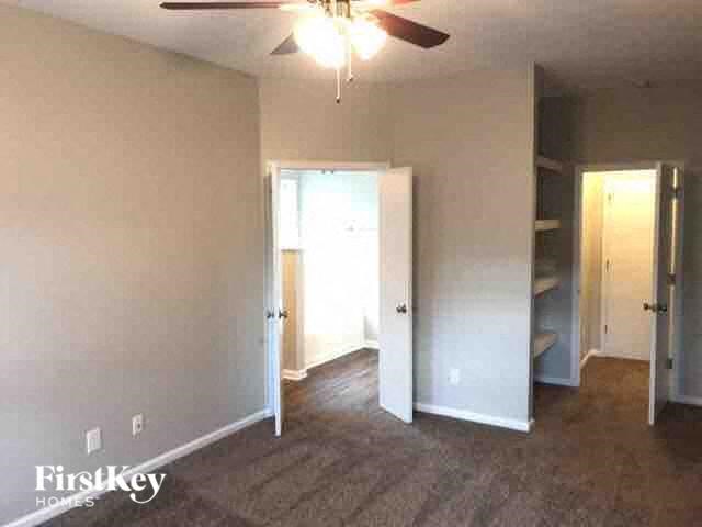 A room with a ceiling fan and a carpeted floor.