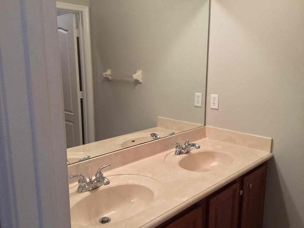 a bathroom with two sinks and a large mirror