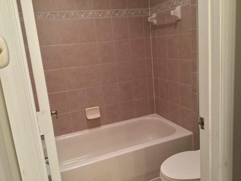 a small bathroom with a toilet and a bath tub