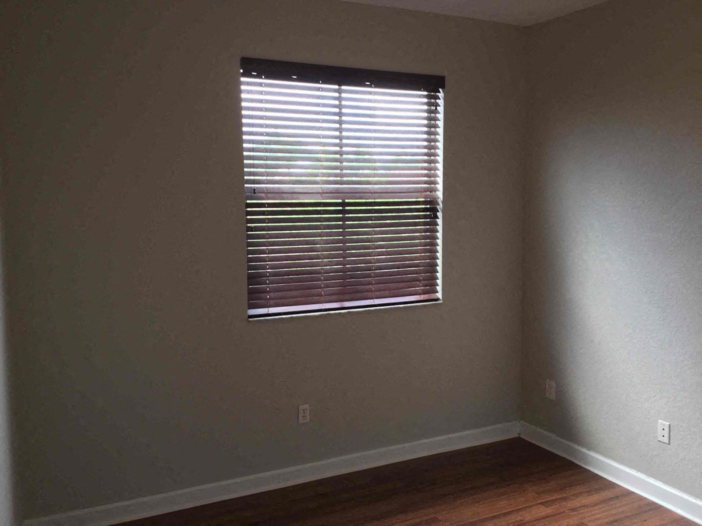 a room with a window and a hard wood floor