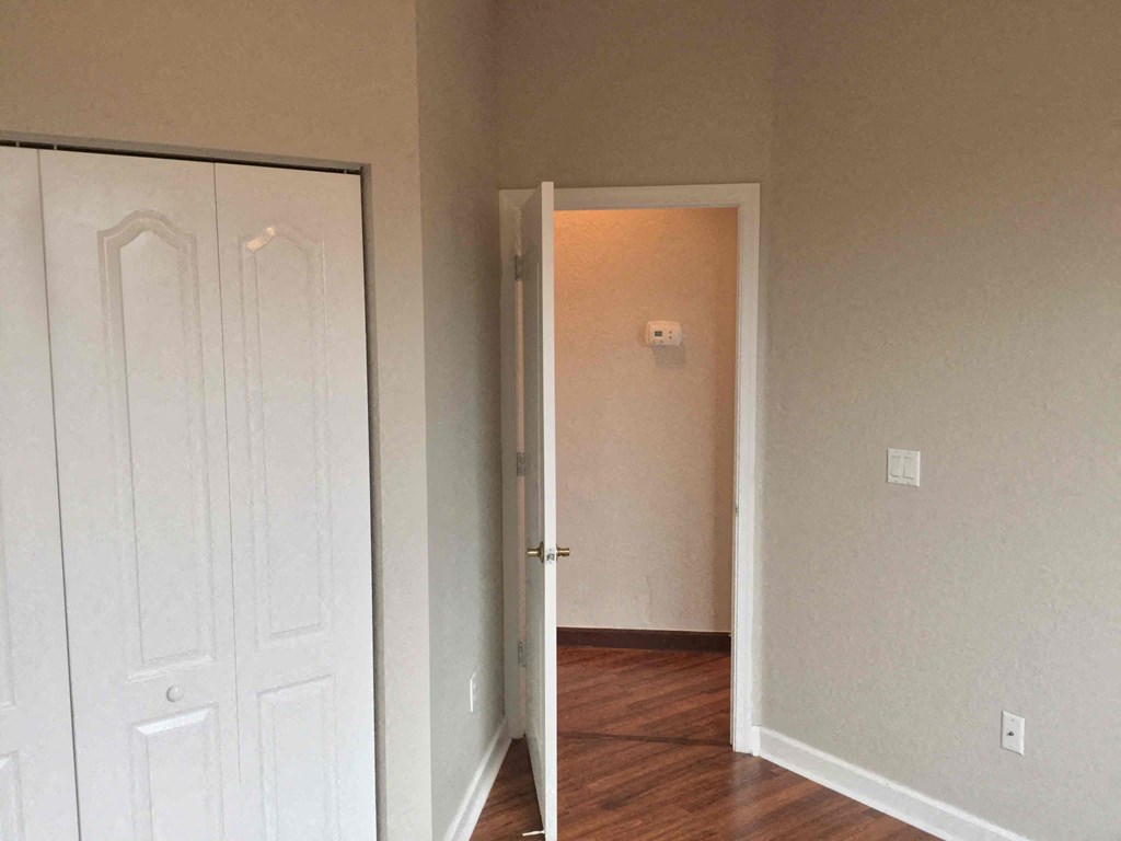an empty room with a door open and a closet
