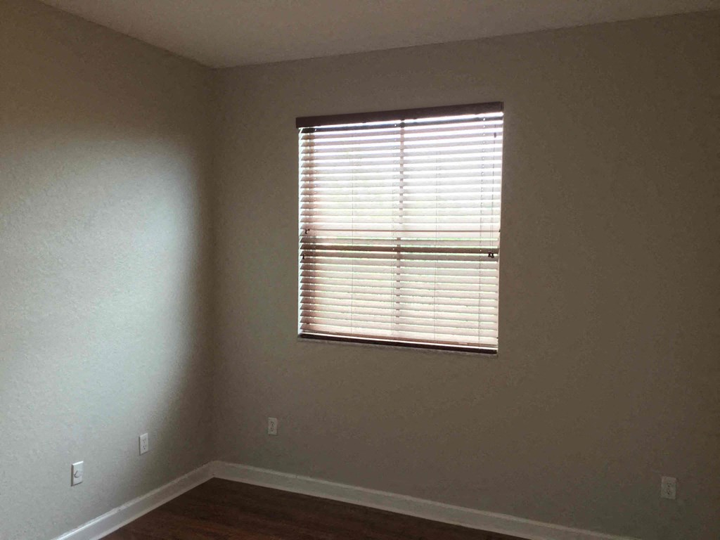 an empty room with a window with blinds on it