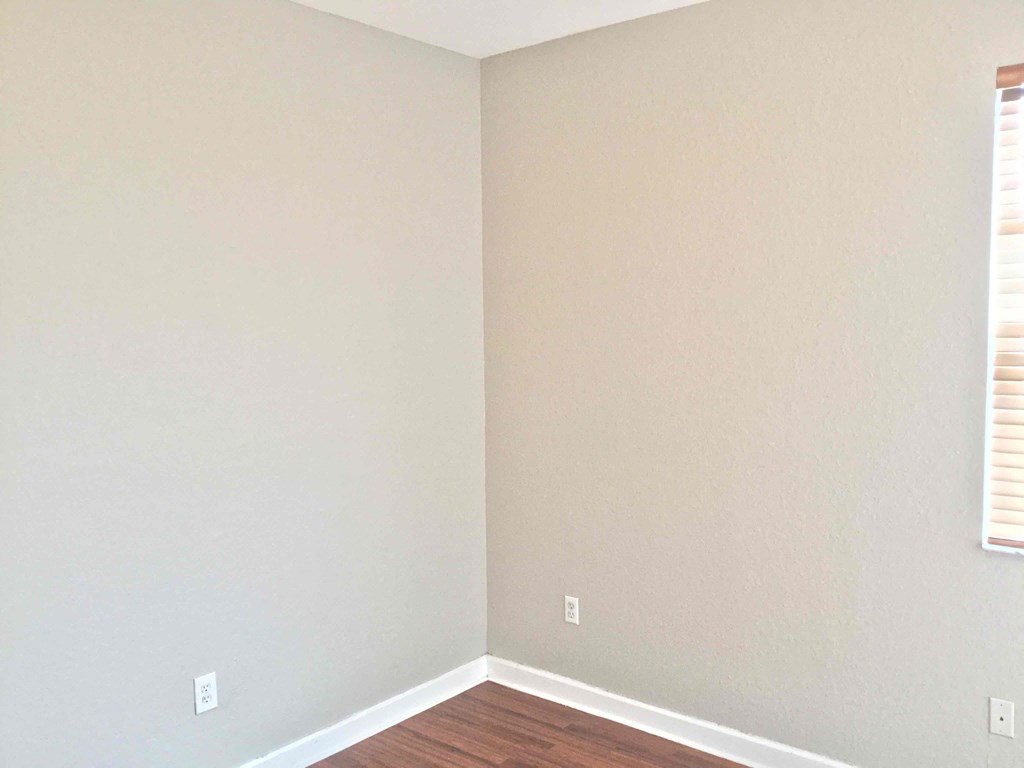 an empty room with wooden floors and white walls