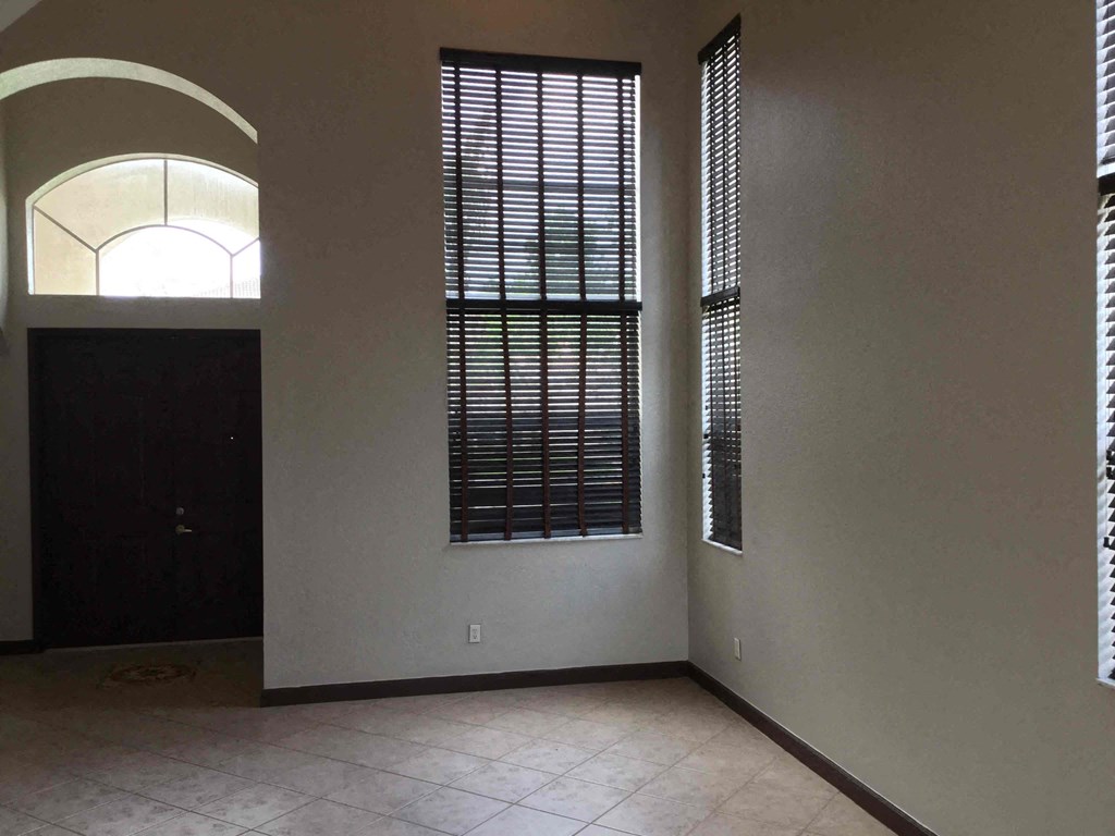 an empty living room with a door and windows