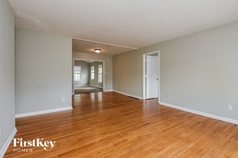 the living room and dining room of an empty house with wood floors