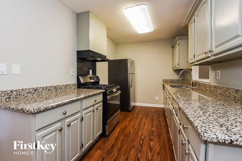 a kitchen with granite counter tops and a black refrigerator