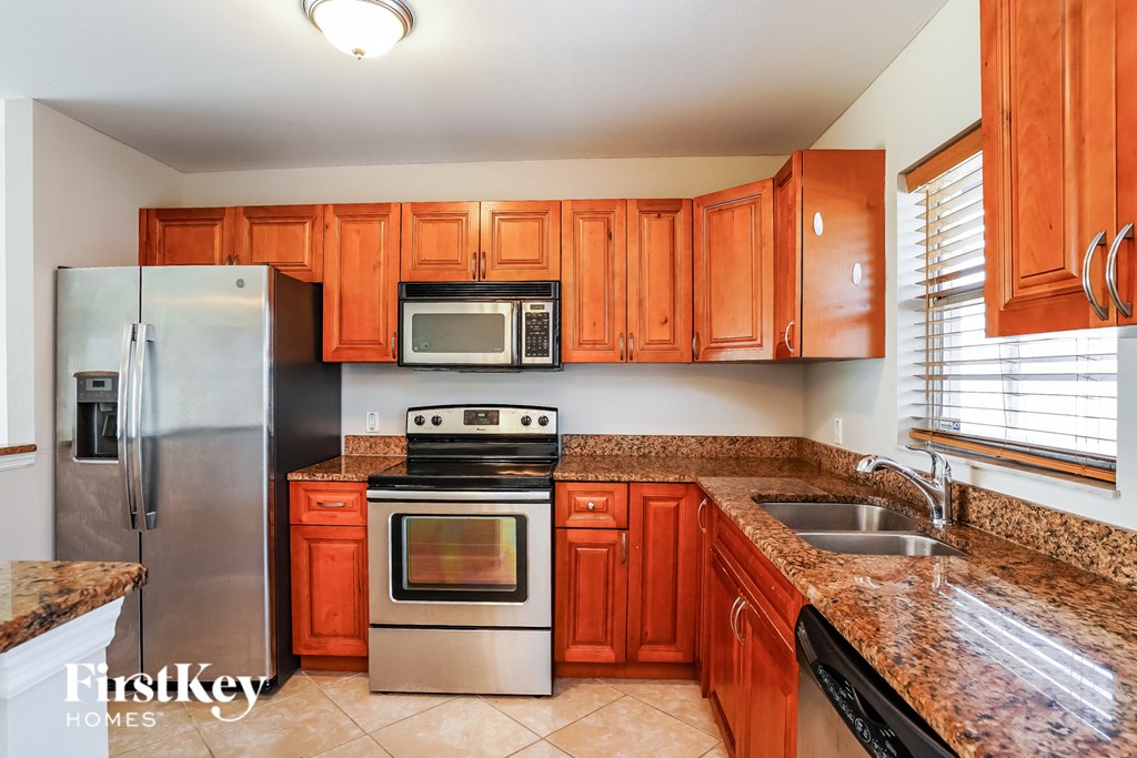 a kitchen with wooden cabinets and stainless steel appliances
