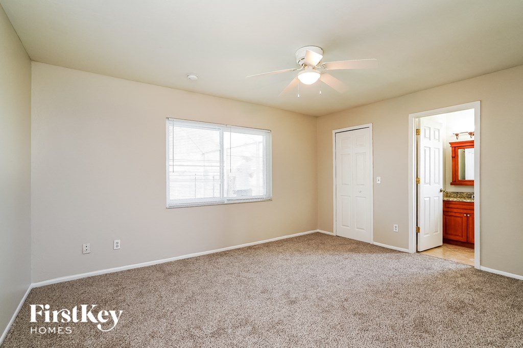a bedroom with carpeted flooring and a ceiling fan