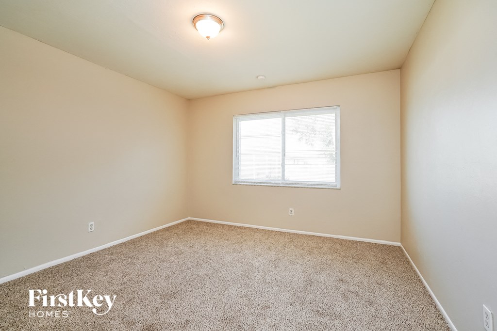the living room of a home with carpet and a window