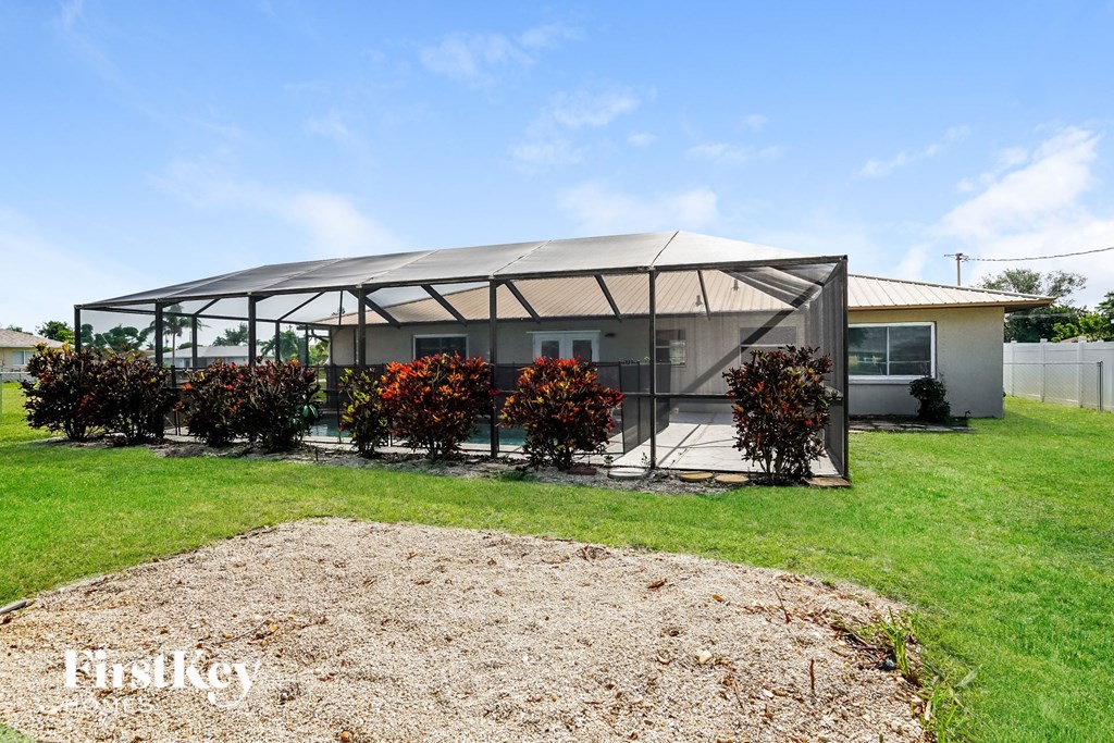 a covered patio with flowers in front of a house