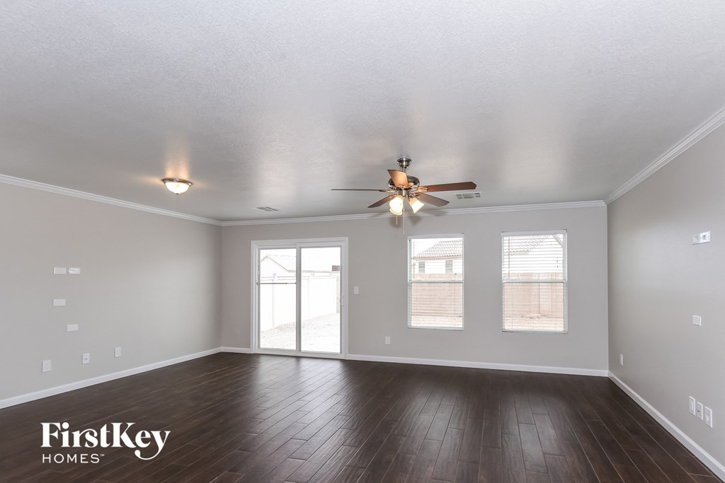 the living room of an empty house with a ceiling fan