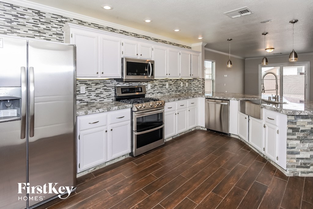 a kitchen with white cabinets and stainless steel appliances
