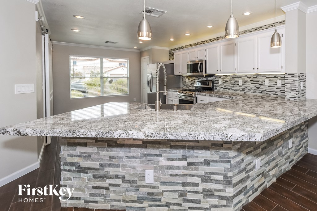 a kitchen with a marble counter top and white cabinets