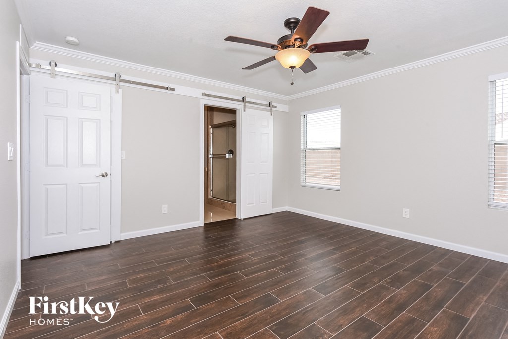 a living room with a ceiling fan and a door to a closet